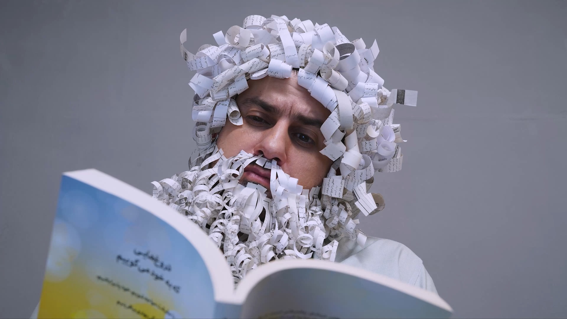 نمایش بلوغ و پختگی حاصل شده از کتاب خواندن با گریم ریش و موی کاغذی